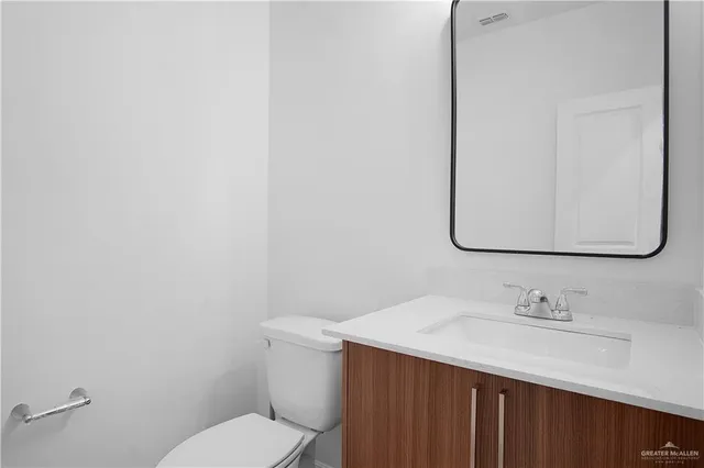 a bathroom with a sink vanity mirror and toilet