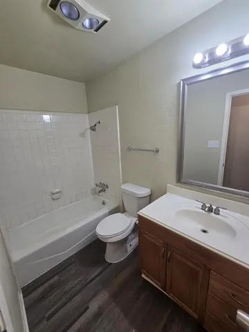 a bathroom with a double vanity sink toilet mirror and bathtub