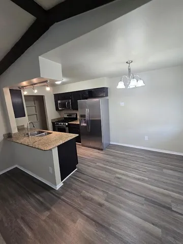 a room with stainless steel appliances wooden floors and view living room