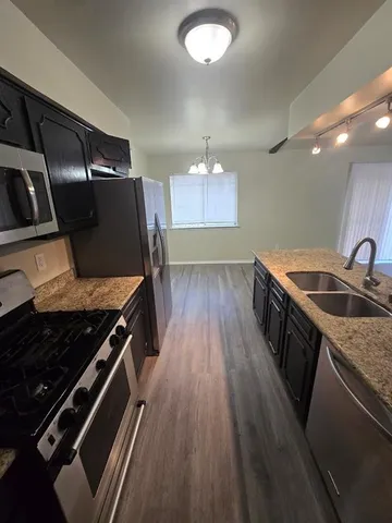 a kitchen with granite countertop a stove and a sink