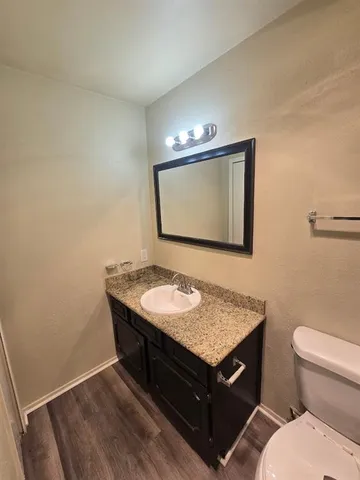 a bathroom with a toilet a sink and mirror