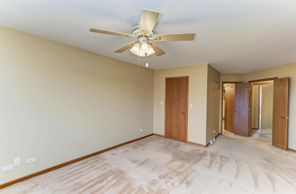 1753 Pebble Beach Drive Hoffman Estates, IL 60169 - Photo 17 of 35 an empty room with closet and a chandelier fan