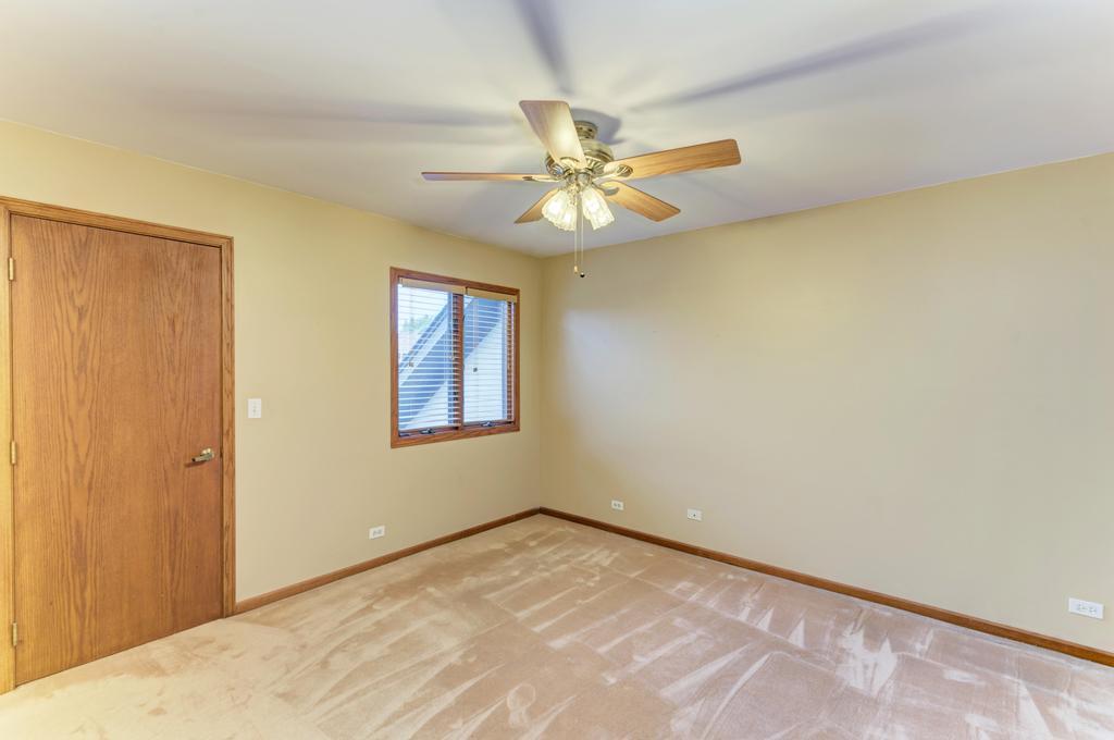 1753 Pebble Beach Drive Hoffman Estates, IL 60169 - Photo 20 of 35 a view of an empty room and window with a ceiling fan