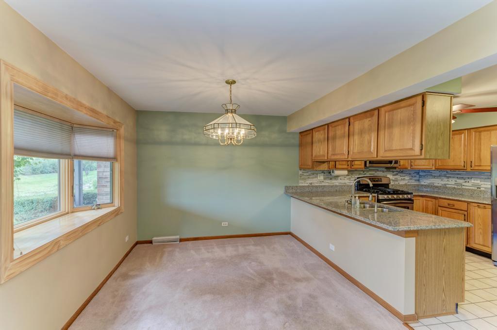1753 Pebble Beach Drive Hoffman Estates, IL 60169 - Photo 9 of 35 a kitchen with stainless steel appliances granite countertop a sink stove and cabinets
