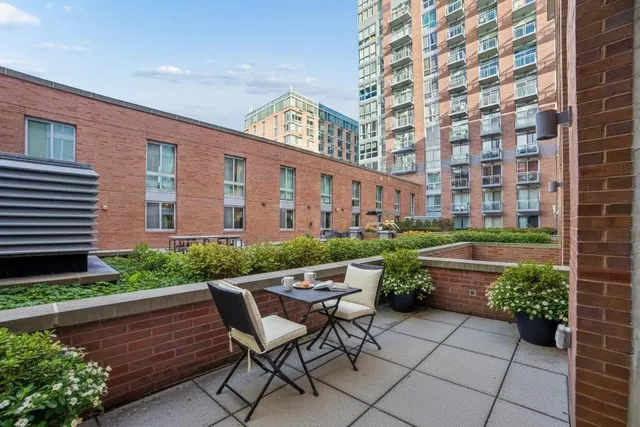 a view of a chairs and table in the back yard of a house