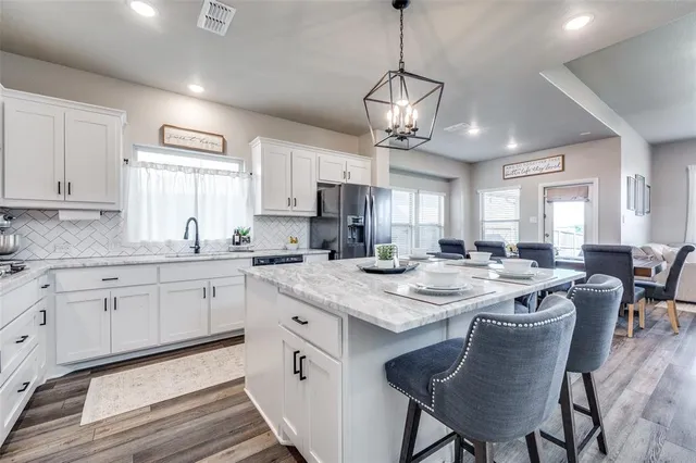 a kitchen with cabinets table and chairs