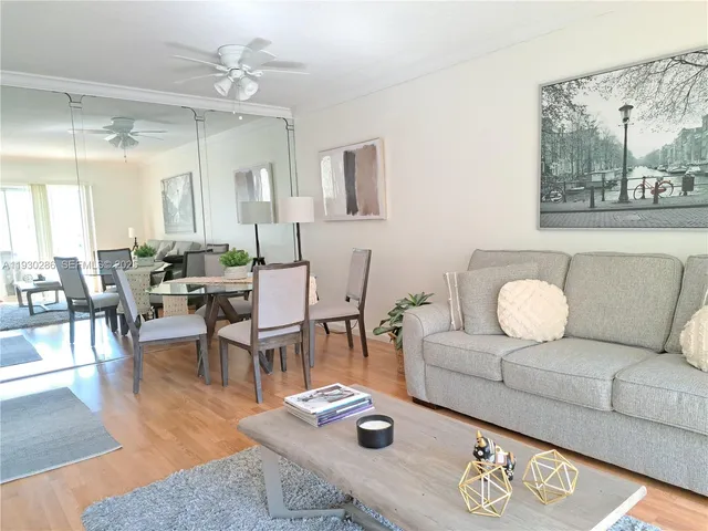 a living room with furniture a rug and a large mirror