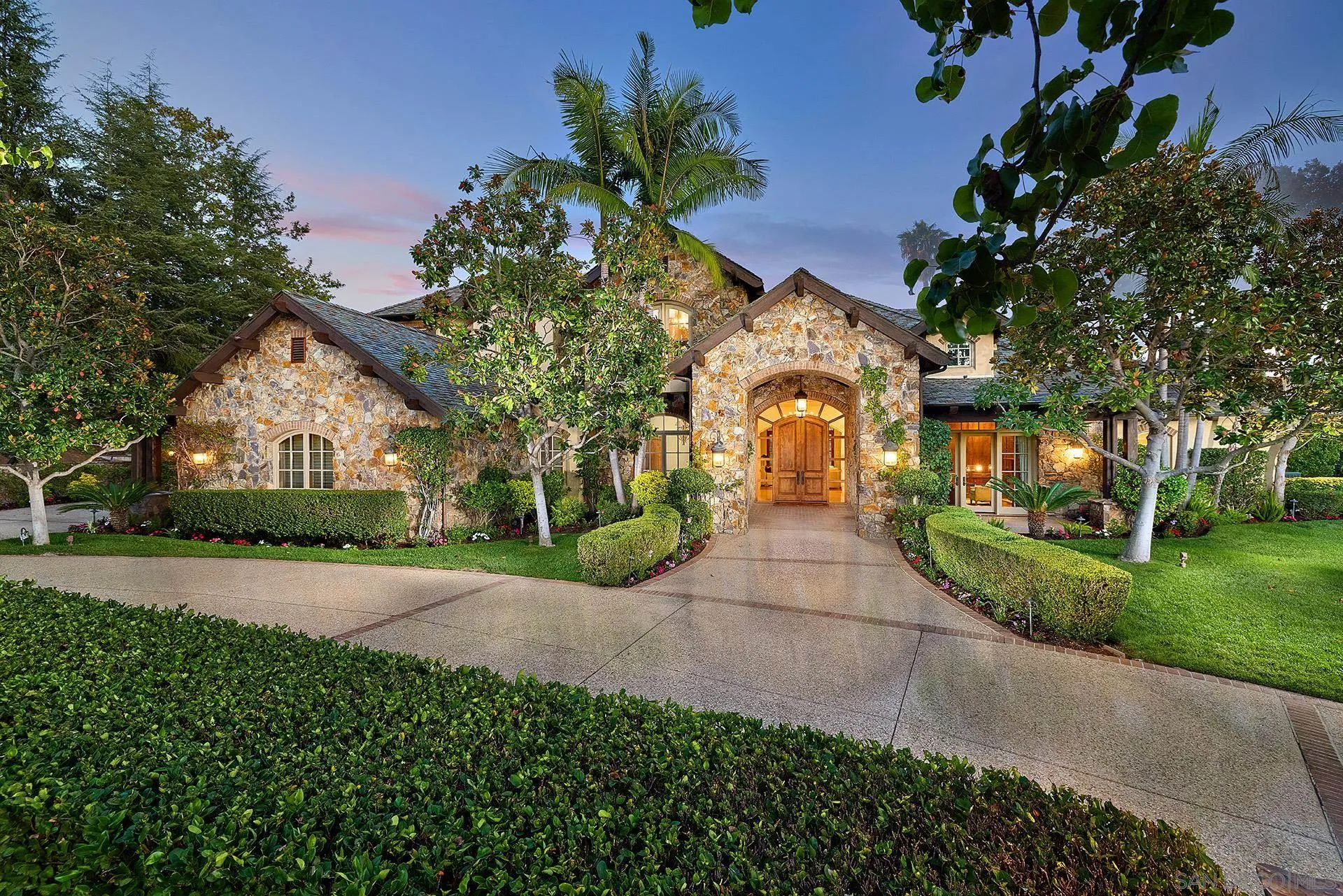 a front view of a house with a yard and a garden