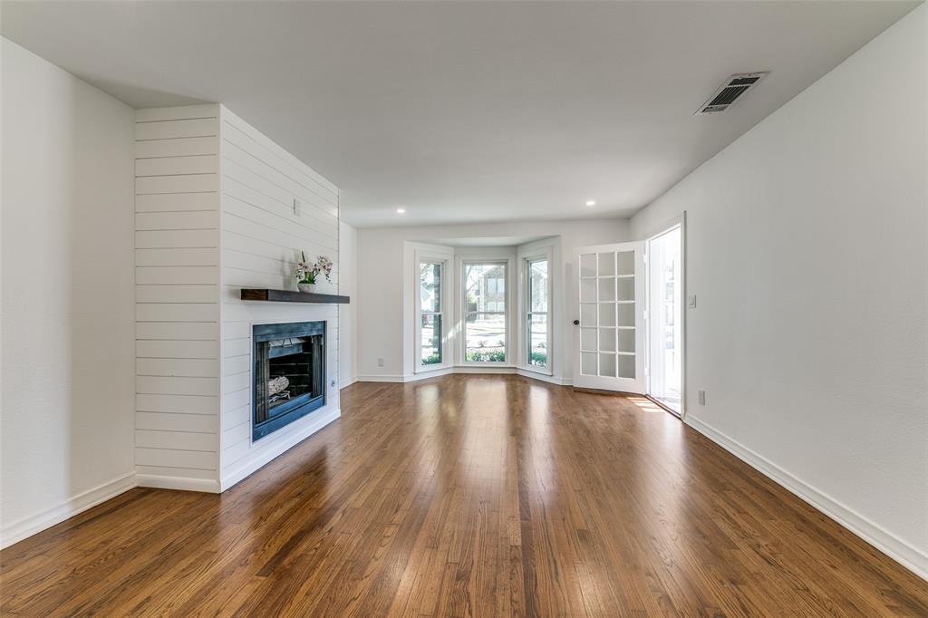 5117 Maple Springs Boulevard Dallas, TX 75235 - Photo 5 of 15 a view of an empty room with wooden floor and a window