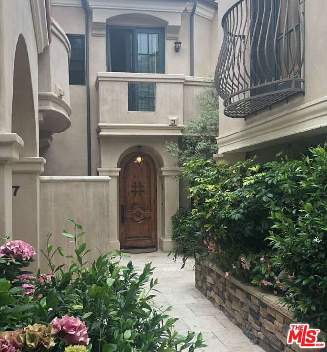 11357 Ovada Place, Unit 2 Los Angeles, CA 90049 - Photo 1 of 13 a front view of a house with a garden