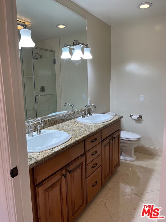 11357 Ovada Place, Unit 2 Los Angeles, CA 90049 - Photo 11 of 13 a bathroom with a granite countertop double vanity sink and a mirror