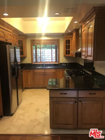 a kitchen with granite countertop a stove and a refrigerator