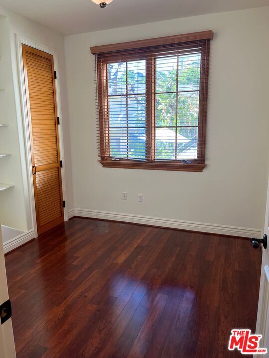 11357 Ovada Place, Unit 2 Los Angeles, CA 90049 - Photo 9 of 13 an empty room with wooden floor and a window