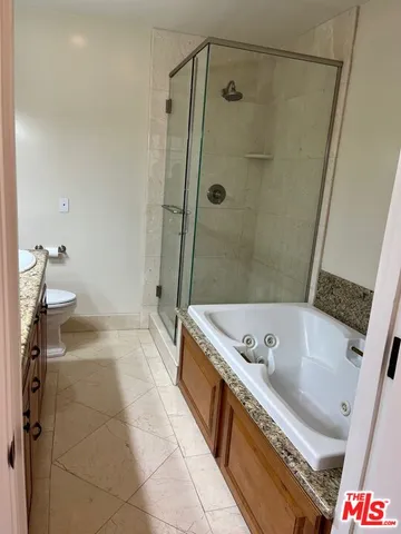a bathroom with a granite countertop double vanity sink and a mirror