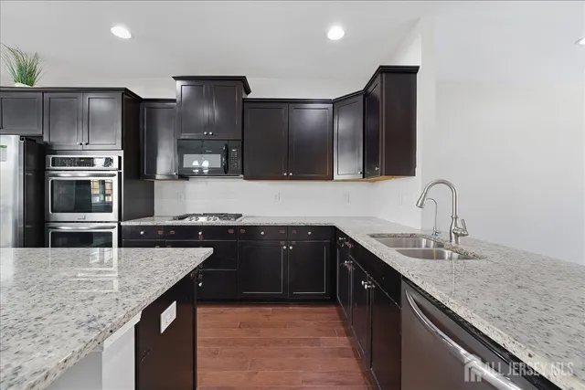a kitchen with stainless steel appliances granite countertop a sink and stove