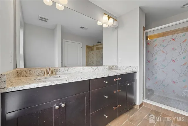 a bathroom with a granite countertop sink toilet and shower