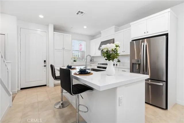 a kitchen with stainless steel appliances a refrigerator and a table