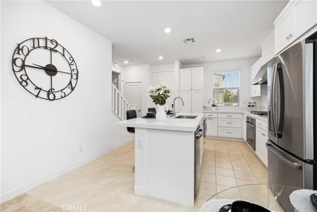 a kitchen with stainless steel appliances kitchen island granite countertop a sink a stove and a refrigerator