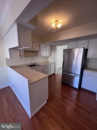 a kitchen with stainless steel appliances a refrigerator a sink a stove a microwave and wooden floor