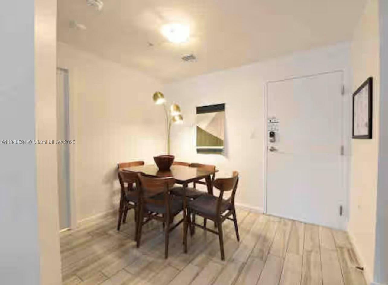 481 Northeast 29th Street, Unit 705 Miami, FL 33137 - Photo 4 of 14 a view of a dining room with furniture and wooden floor