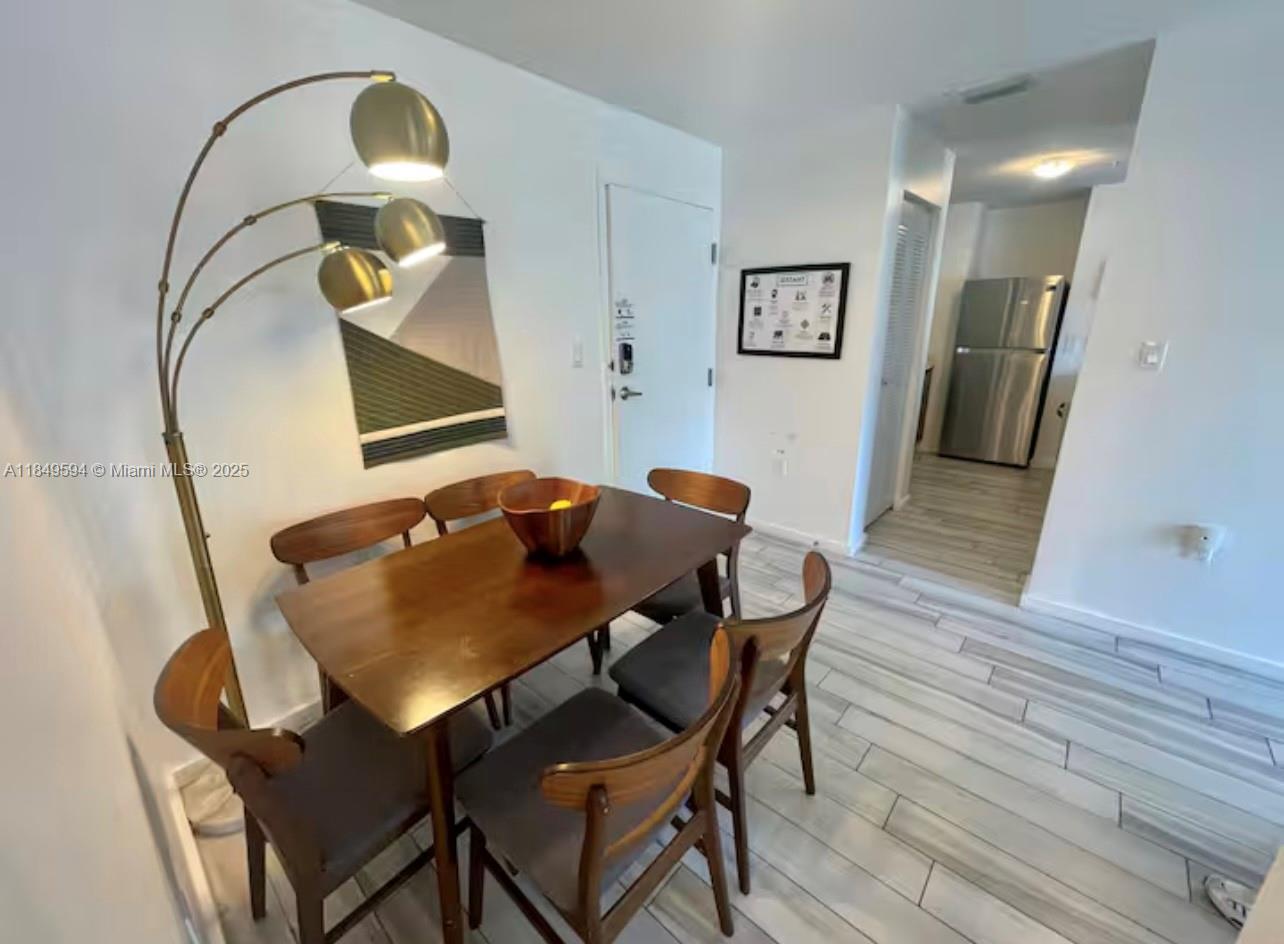 481 Northeast 29th Street, Unit 705 Miami, FL 33137 - Photo 5 of 14 a view of a dining room with furniture and wooden floor