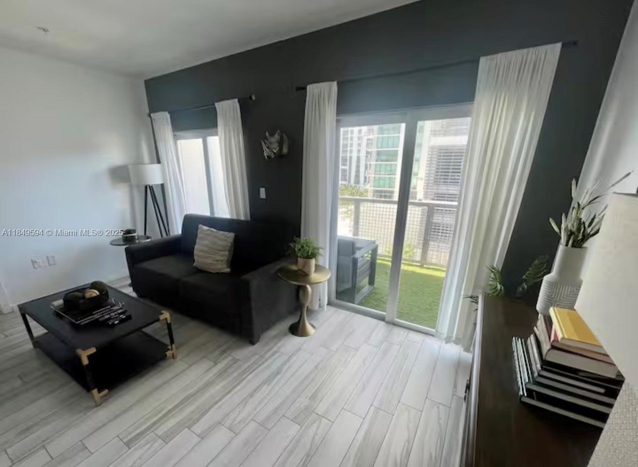 481 Northeast 29th Street, Unit 705 Miami, FL 33137 - Photo 6 of 14 a living room with furniture and a wooden floor
