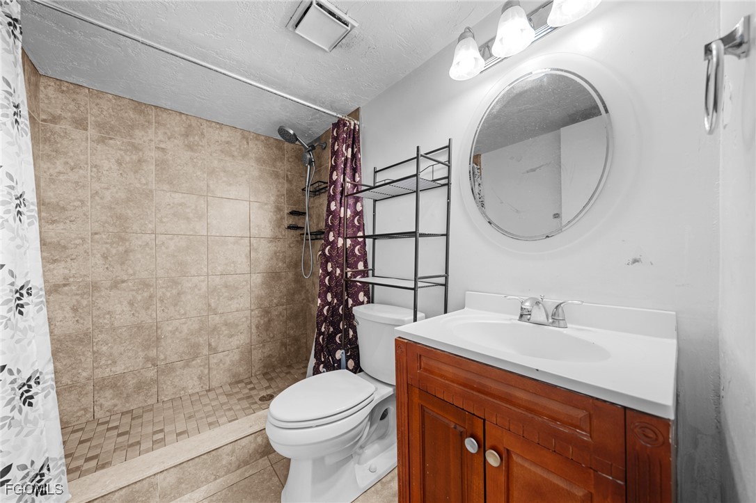 830 Wiggins Pass Road, Unit 14 Naples, FL 34110 - Photo 11 of 20 a bathroom with a sink a toilet and a mirror