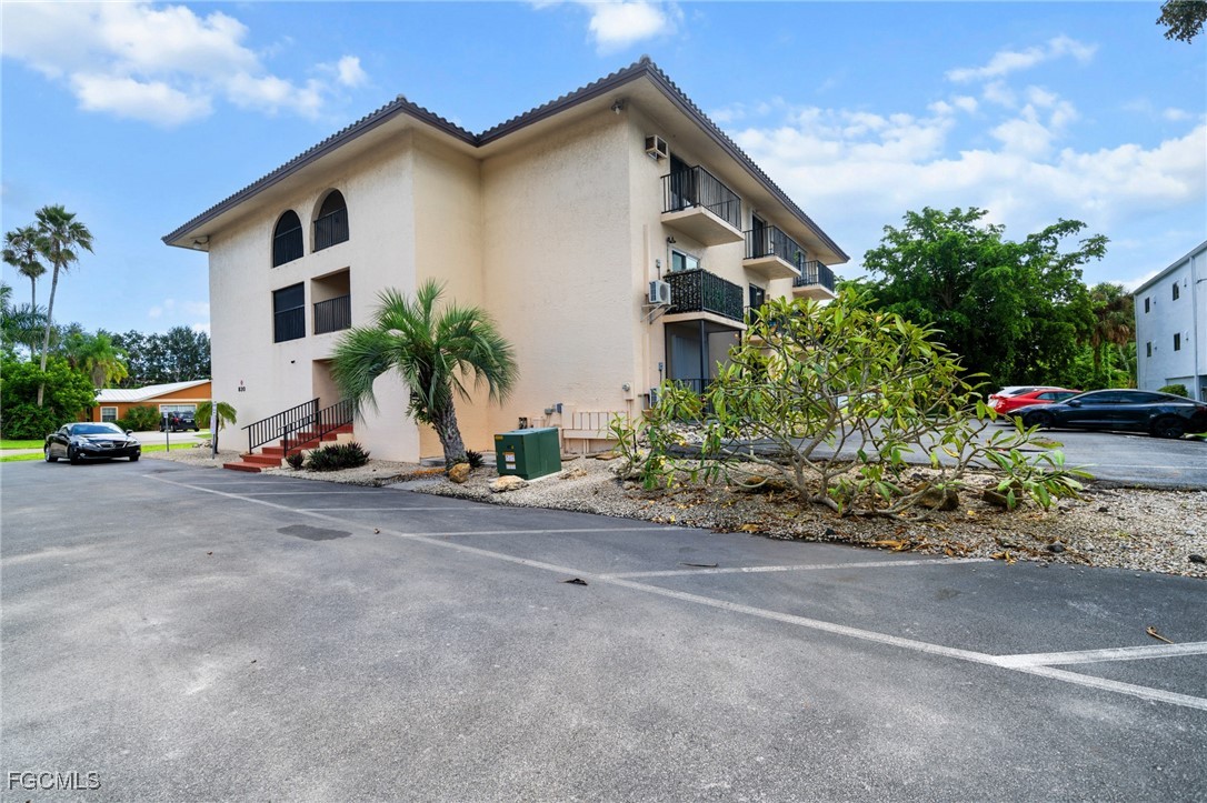830 Wiggins Pass Road, Unit 14 Naples, FL 34110 - Photo 17 of 20 a front view of a house with a yard and a garage