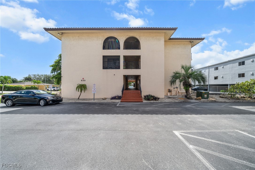 830 Wiggins Pass Road, Unit 14 Naples, FL 34110 - Photo 18 of 20 a view of a car parked in front of a house