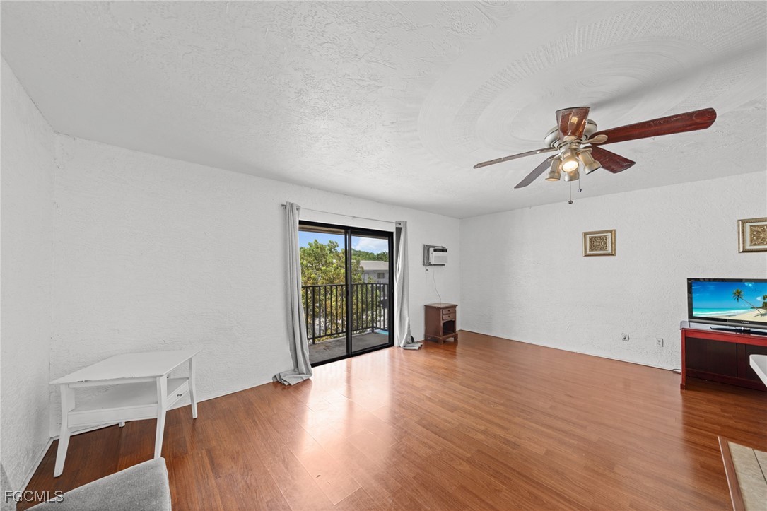830 Wiggins Pass Road, Unit 14 Naples, FL 34110 - Photo 3 of 20 wooden floor in an empty room with a window