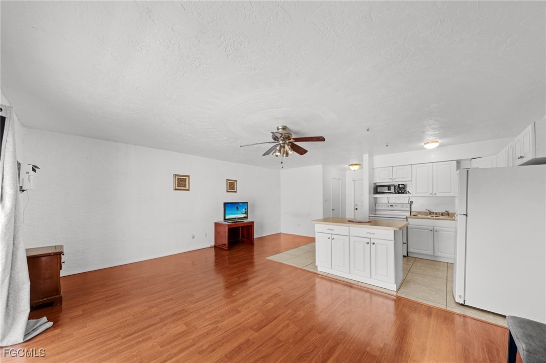 830 Wiggins Pass Road, Unit 14 Naples, FL 34110 - Photo 5 of 20 a living room with stainless steel appliances kitchen island hardwood floor sink and stove