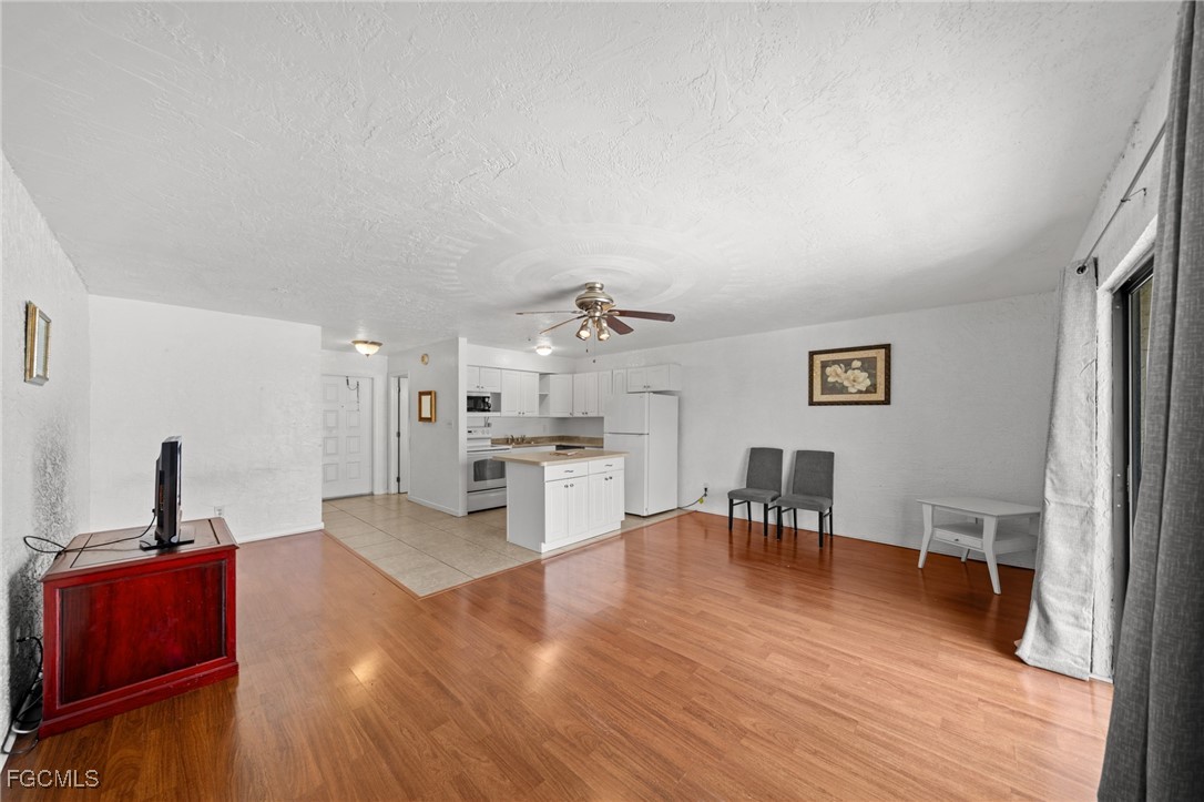 830 Wiggins Pass Road, Unit 14 Naples, FL 34110 - Photo 6 of 20 a living room with furniture and a wooden floor