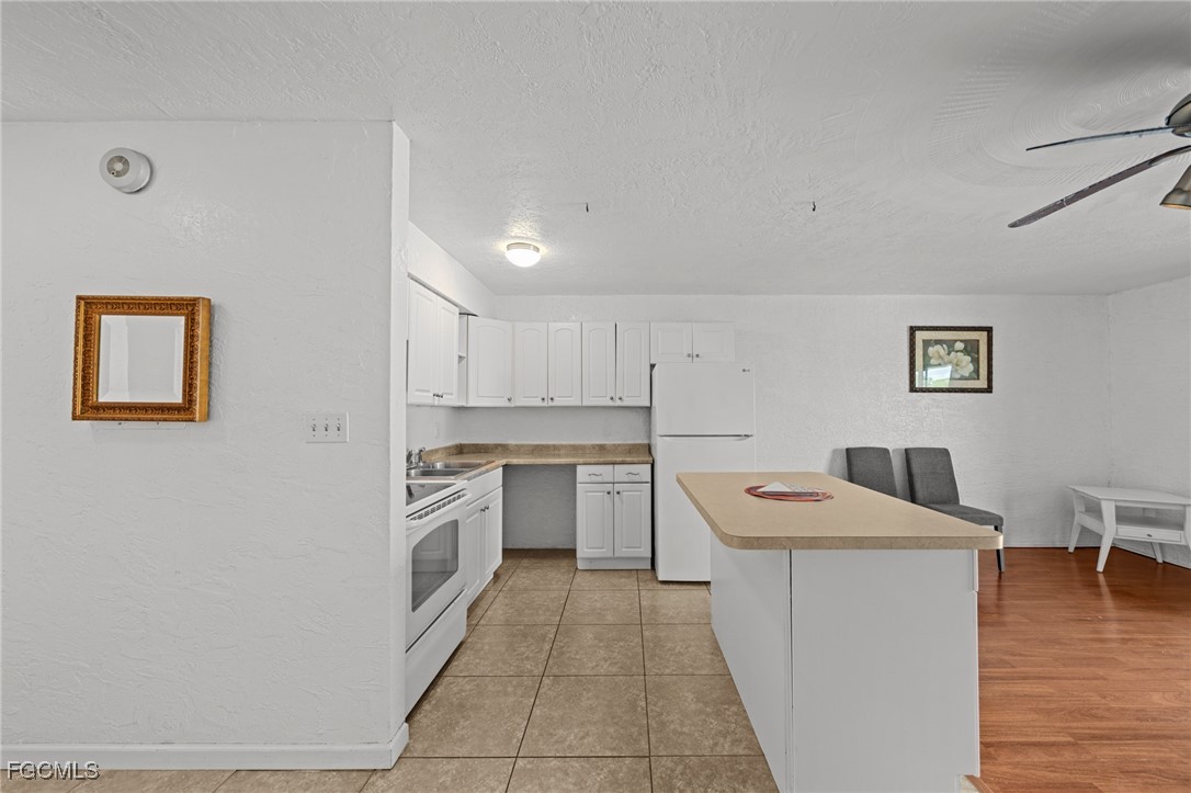 830 Wiggins Pass Road, Unit 14 Naples, FL 34110 - Photo 8 of 20 a kitchen with a sink stove and wooden floor
