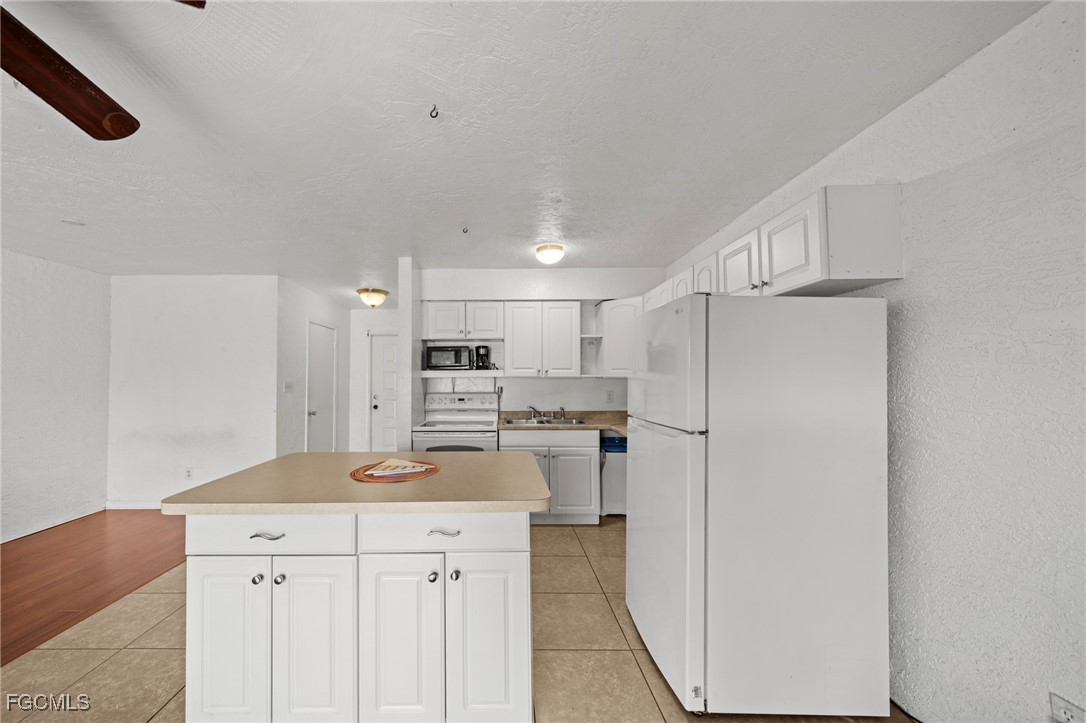 830 Wiggins Pass Road, Unit 14 Naples, FL 34110 - Photo 9 of 20 a kitchen with stainless steel appliances a refrigerator and a stove top oven
