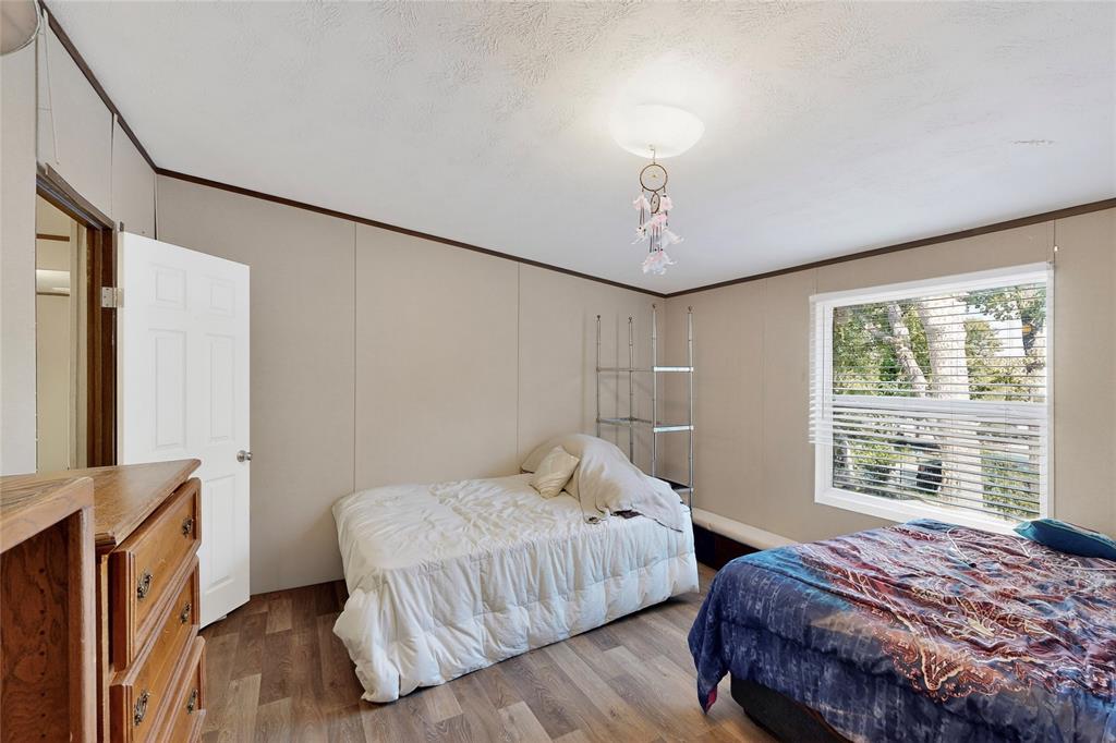 7219 Rucker Street Azle, TX 76020 - Photo 9 of 16 a bedroom with a bed and a chandelier