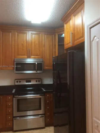 a kitchen with a refrigerator stove and microwave