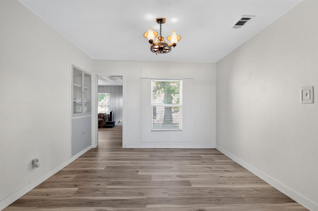 5485 Highway 7 Marlin, TX 76661 - Photo 26 of 36 Unfurnished room with wood finished floors and a chandelier