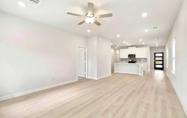 an empty room with wooden floor and windows