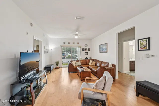 a living room with furniture flat screen tv and a large window