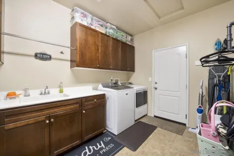 a utility room with cabinets washer and dryer