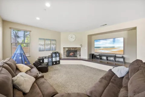 a living room with furniture a large window and a fireplace