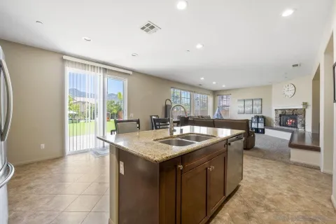 a kitchen with a stove a sink a counter top space and living room