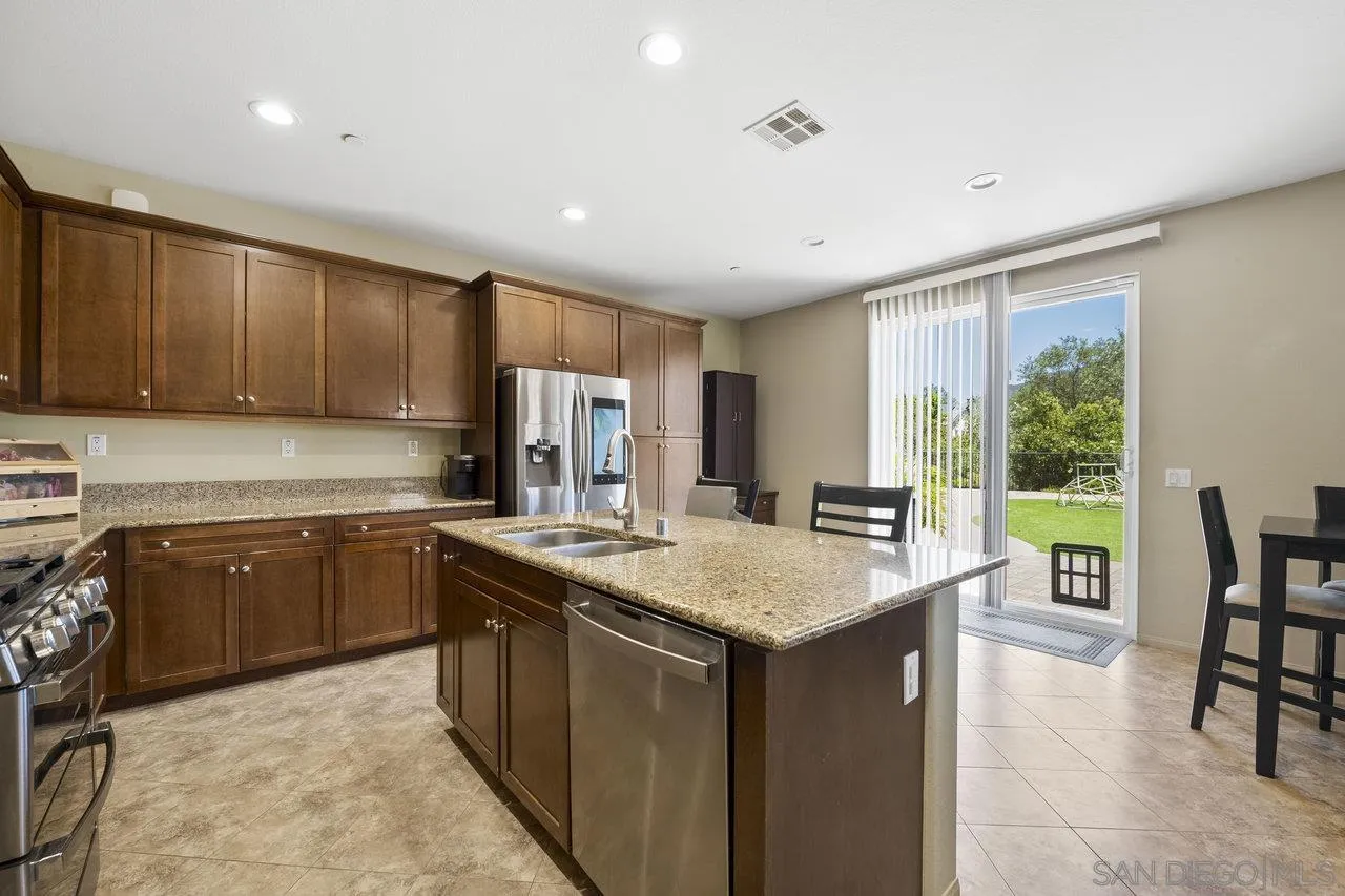 2928 Burnet Drive Escondido, CA 92027 - Photo 19 of 39 a kitchen with a stove a sink a refrigerator and chairs