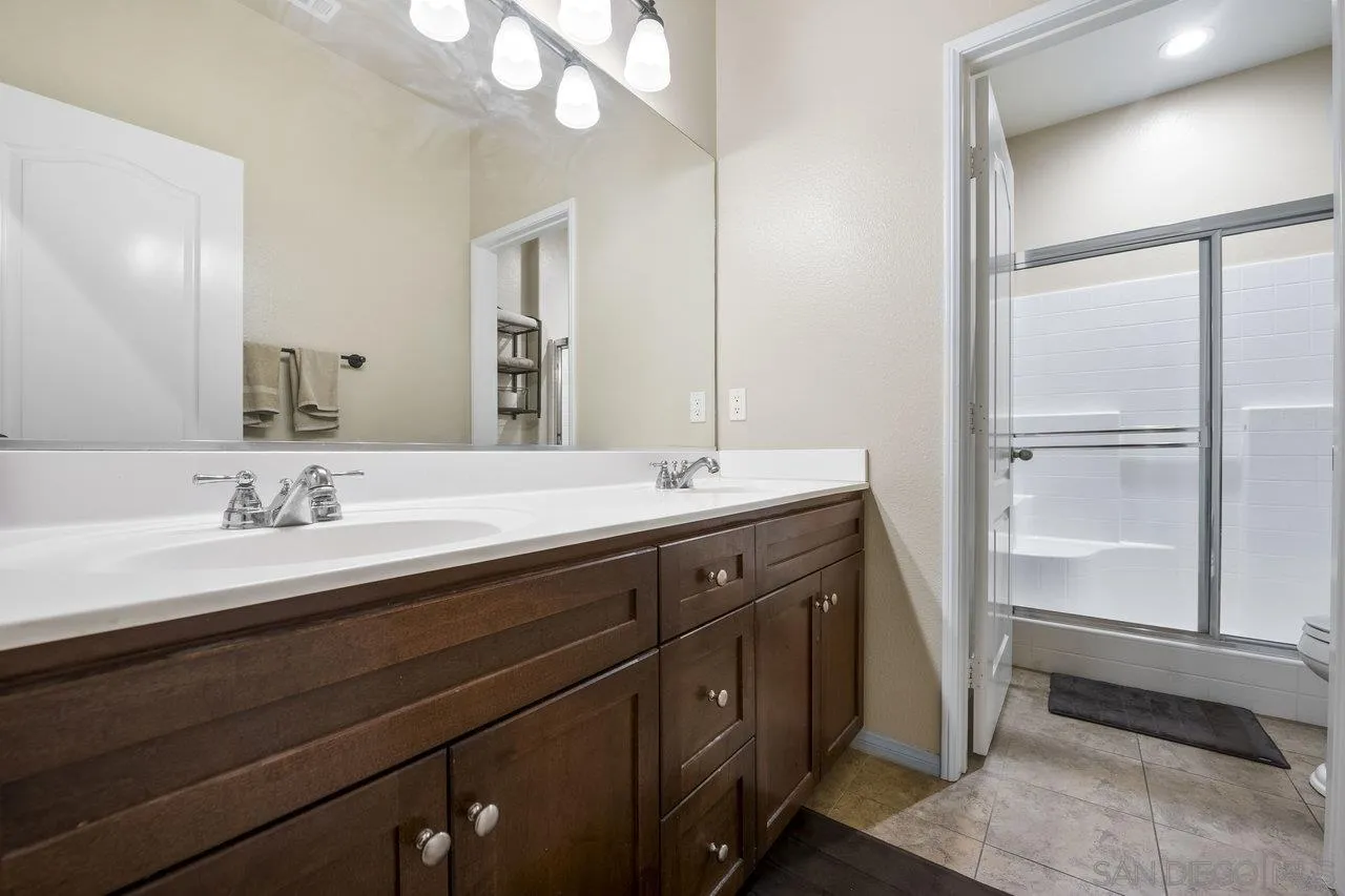 2928 Burnet Drive Escondido, CA 92027 - Photo 25 of 39 a bathroom with a double vanity sink and a mirror