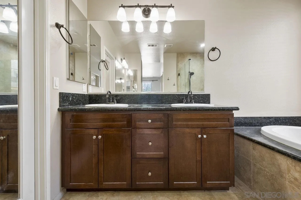 2928 Burnet Drive Escondido, CA 92027 - Photo 5 of 39 a bathroom with a granite countertop sink a mirror and a vanity