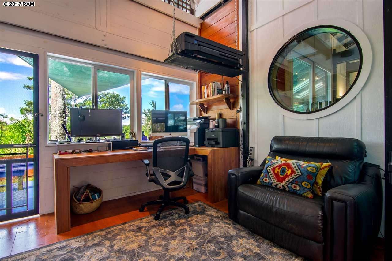 690 East Kuiaha Road Haiku, HI 96708 - Photo 15 of 30 a living room with a couch a rug a flat screen tv and a floor to ceiling window