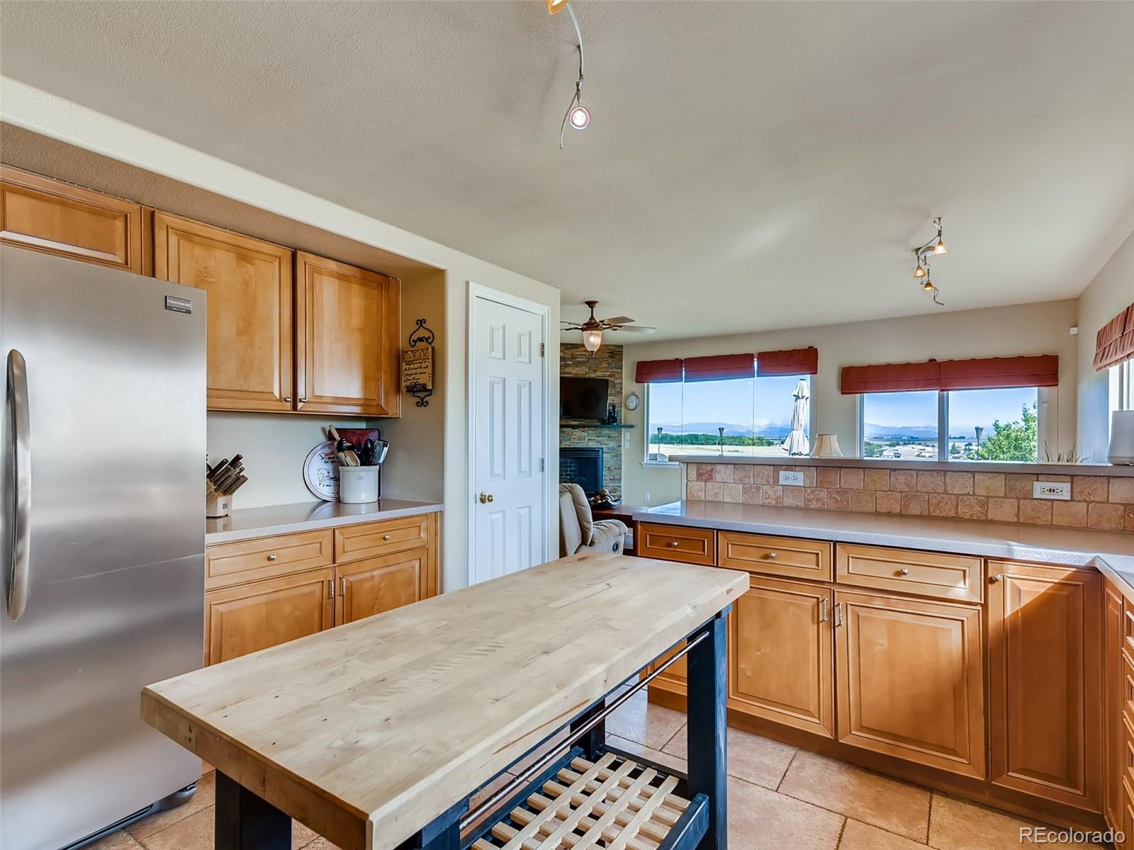 8209 County Road 2 Brighton, CO 80603 - Photo 11 of 40 a kitchen with stainless steel appliances kitchen island granite countertop a table chairs sink and cabinets