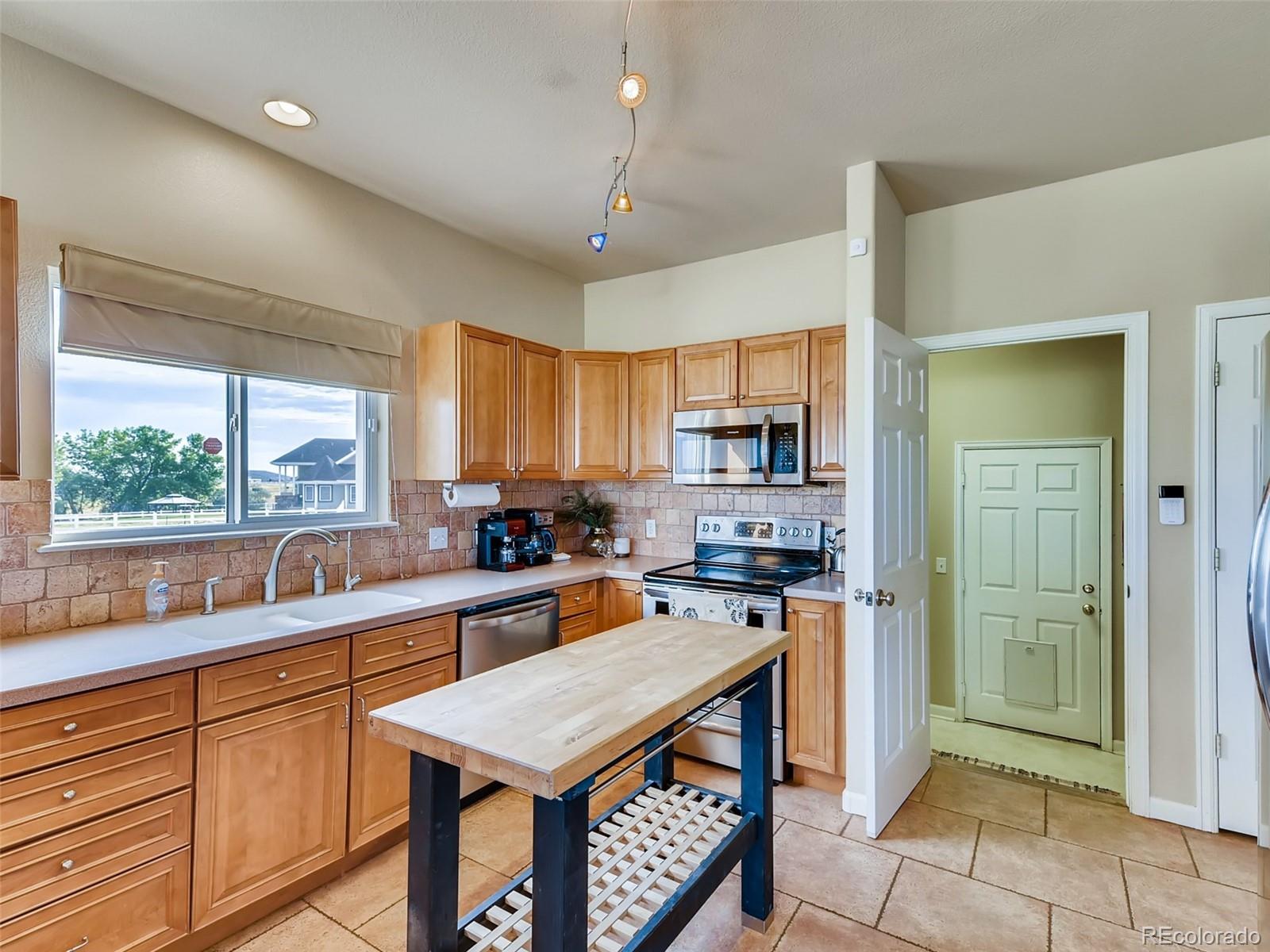 8209 County Road 2 Brighton, CO 80603 - Photo 12 of 40 a kitchen with stainless steel appliances a stove a sink a refrigerator and cabinets