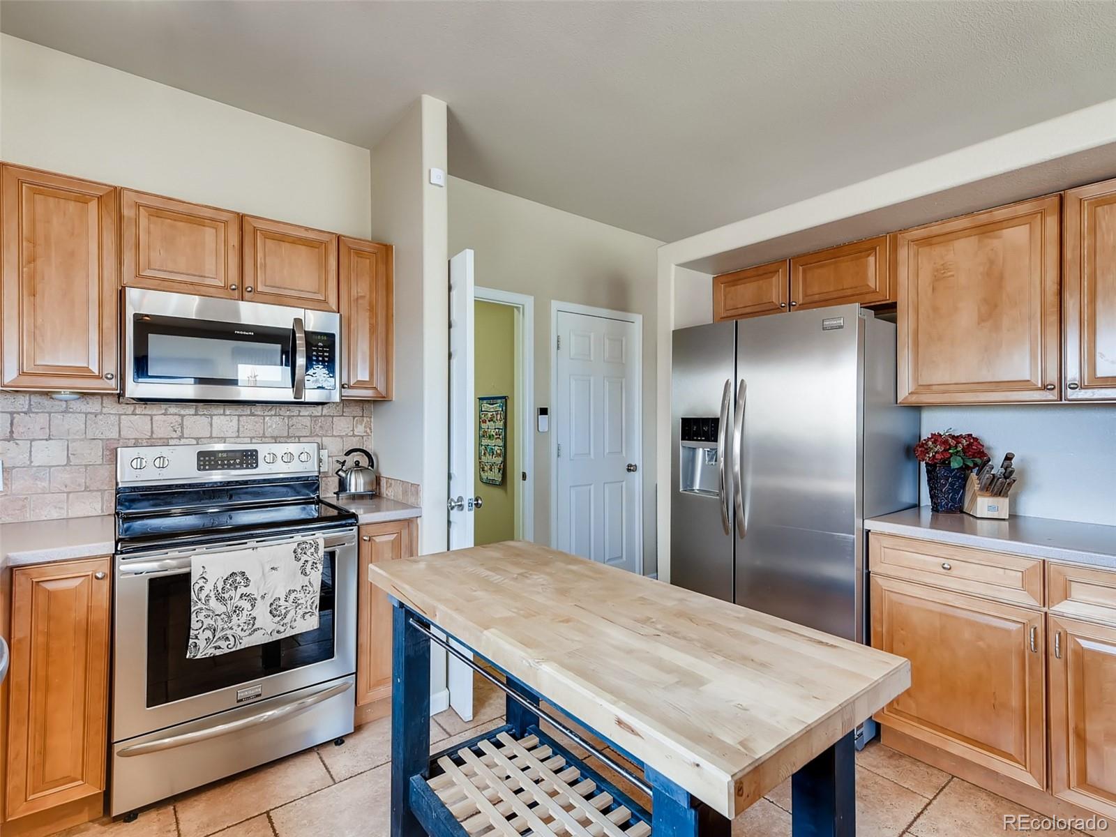 8209 County Road 2 Brighton, CO 80603 - Photo 13 of 40 a kitchen with stainless steel appliances granite countertop a refrigerator a stove top oven a sink and dishwasher