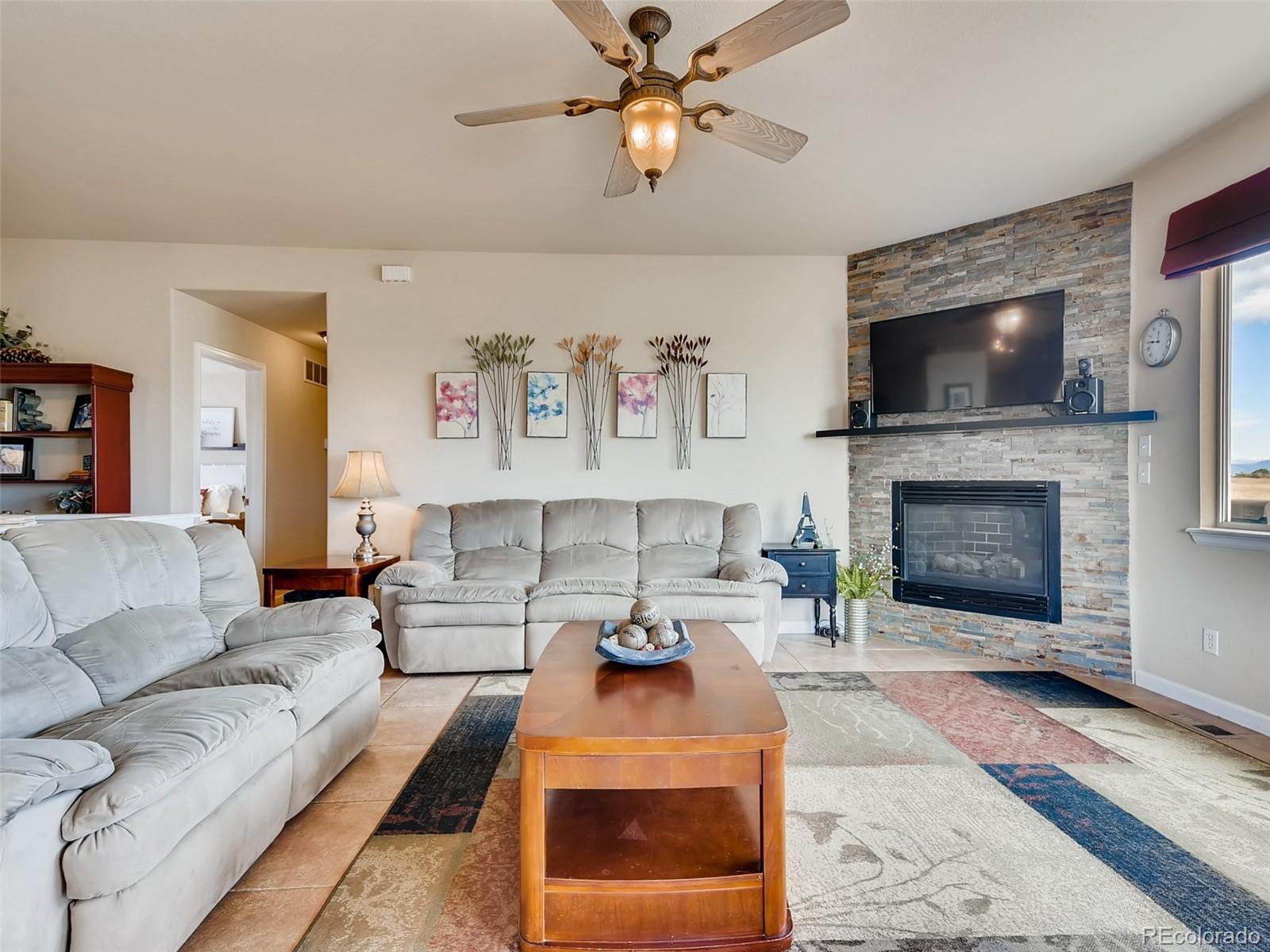 8209 County Road 2 Brighton, CO 80603 - Photo 14 of 40 a living room with furniture a flat screen tv and a fireplace